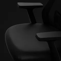 This close-up focuses on the adjustable T-shaped armrests and the contoured seat of our ergonomic chair. These elements are designed to reduce strain on your shoulders and provide a comfortable seating foundation.