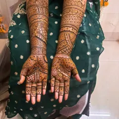 This full-arm mehandi shows a mix of geometric checks, floral patterns, and bold lines, creating a rich and textured look.