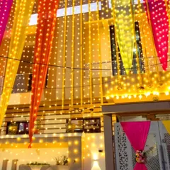 A beautiful night view of a wedding house decorated with colorful drapes and lit up with strings of fairy lights. This creates a warm and magical glow for your evening functions.