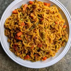A bowl of my special street-style Maggi, cooked with chopped carrots, peas, and a blend of spices to elevate the classic instant noodles. It's the ultimate comfort food for any time of the day or night.