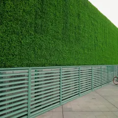 This large-scale commercial installation showcases a massive artificial green wall, creating a striking and modern exterior facade. The high-quality, UV-resistant turf ensures the building stands out with vibrant, year-round greenery, perfect for corporate offices or public buildings in Bangalore.