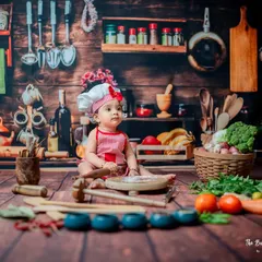 A moment of quiet contemplation with a tiny rolling pin. This shot showcases the detailed setup of the kitchen theme, from the spice rack in the background to the scattered flour on the floor.