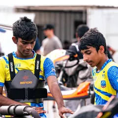 Two of our senior drivers discussing strategy and kart setup with a coach in the pits. Constant communication and analysis are key to improving performance throughout a race weekend.