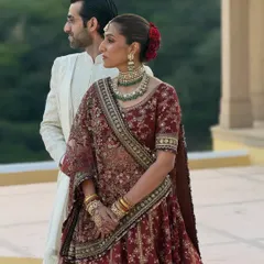 A beautiful portrait of the bride and groom. Her makeup features a classic red lip and defined eyes, creating a timeless look that stands out beautifully against the palace architecture of Jaipur.