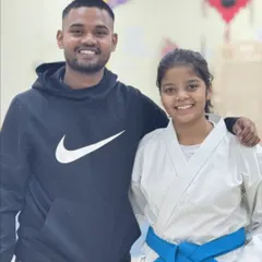A proud coach with his blue-belt student. The mentorship and personal guidance provided by our coaches are fundamental to our students' growth and success.