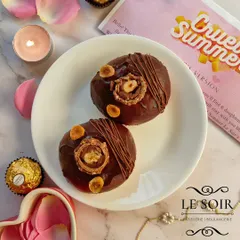 My Ferrero Crunch Doughnut is pure indulgence. It's a baked ring doughnut topped with rich chocolate ganache, roasted hazelnuts, a Nutella drizzle, and a whole Ferrero Rocher.