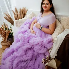 Our studio wardrobe features stunning pieces like this lavender ruffled gown that adds so much drama and elegance. We styled this shot in our Jayanagar studio with a boho-chic setup to create a warm, inviting atmosphere for this beautiful mom-to-be.