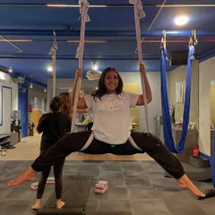 Achieving a full split in the hammock with a huge smile. This is a perfect example of celebrating a personal win within our supportive group.