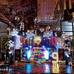 This is a full disco-themed party setup I designed. It features a custom LED screen backdrop, silver disco balls, and themed cutouts to create a high-energy environment perfect for office celebrations and milestone parties.
