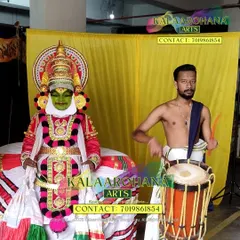 A behind the scenes look at our artists. A Kathakali performer stands in full costume next to a Chendemelam artist with his drum, showcasing two key elements of Kerala's performance arts.