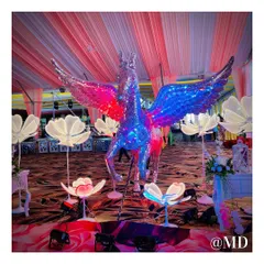 A truly magical photo booth featuring a life-sized, winged horse statue made of reflective mirrors. The statue is surrounded by glowing floral lights, creating a fantasy-like setting for pictures.