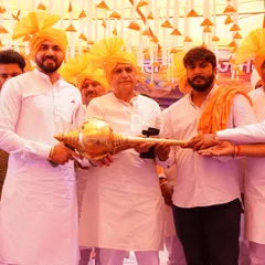 Being honored with a traditional 'Gada' at the community event, a symbol of strength and responsibility.