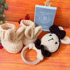 A sweet bunny-themed gift set, this pair of beige bunny-ear booties comes with a matching bunny rattle, complete with a dark brown bow.