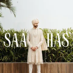 A stylish and modern portrait of the groom in his ivory sherwani. The clean typography with his name adds a personalized, magazine-like feel to the shot.