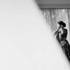 A beautifully composed black and white shot of the bride getting ready, using negative space to create an artistic and pensive mood.