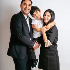 Laughter and love in this classic family portrait. Having the son on his father's back adds a fun, dynamic element to the shot.