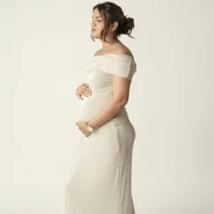 A quiet, contemplative side profile in a beautiful off shoulder gown. This pose is perfect for elegantly showcasing the baby bump and capturing a moment of inner peace.