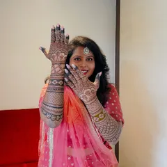 Anusha, a beautiful bride, joyfully showing off her intricate mehendi. Her smile says it all.
