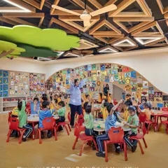 A classroom at GD Goenka Public School, Vasant Kunj, where children are actively engaged in a lesson. The design features playful ceiling elements and a wall covered in student artwork, creating a stimulating and personalized learning space.