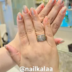 A sophisticated design on almond-shaped nails, featuring a nude base with delicate, wavy silver glitter lines.