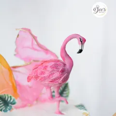 A detailed look at the hand-sculpted flamingo topper, showing the texture on its feathers.