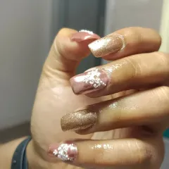 For this bride, I created a custom set with rose gold chrome, glitter, and intricate, hand-painted henna-style art in white to complement her mehndi. This shows how I can personalize your nails to match any theme.