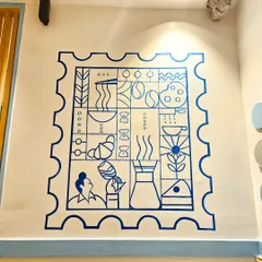 This minimalist 'duty free stamp' mural was designed for a cafe, incorporating elements like coffee, pasta, and croissants into a clever, graphic composition.