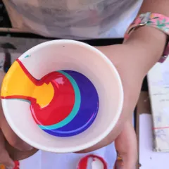 The moment before the pour. Layering different acrylic paint colors in a cup is the first step to creating a unique, multi-colored abstract design.