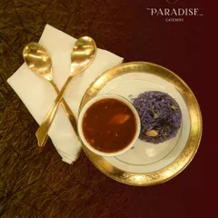 A feast to remember. This plate of purple rice and savory curry, served with golden spoons, represents the elegant and unforgettable catering we are known for.