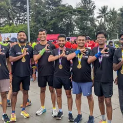 The team showing off their well-earned medals. The matching 'Champions' tees represent the unity and shared goals of our running group.