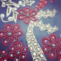 A beautiful example of katdaana beadwork. I used red thread and silver beads to create these floral motifs on a grey fabric, a stunning combination that adds intricate detail to any outfit.