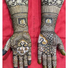 This semi bridal design features a unique asymmetrical layout, with a peacock on one hand and a pair of swans on the other. It also showcases negative space or cutwork techniques around the lotus motifs.