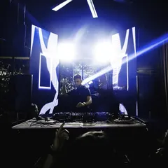 A wide shot showing the full effect of a custom visual setup at Raahi, with bright lights framing the large LED screen behind me.