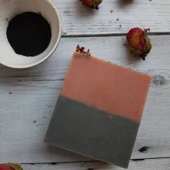 A simple, elegant bar of Charcoal Rose soap. The two-tone layer design shows the combination of French pink clay for gentle cleansing and activated charcoal for a deeper clean.
