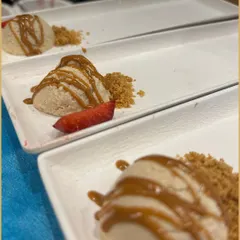 A beautifully plated dessert featuring a scoop of creamy mousse, a drizzle of caramel, and a sprinkle of buttery crumble. This dish showcases our attention to detail in creating elegant and indulgent sweet courses.