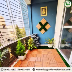 The finished balcony at Kudlu Gate. We used a combination of durable WPC tiles and artificial grass for the flooring, and added a compact water fountain and potted plants to create a serene atmosphere.
