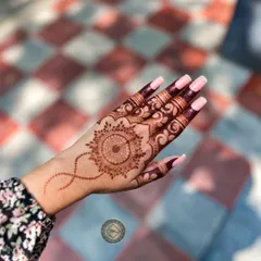 A simple and elegant mandala on the back of the hand. The design is perfectly centered and complemented by detailed work on the fingers.