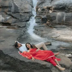 Finding stillness together. This serene pre-wedding portrait by a cascading waterfall captures a moment of pure peace and connection, away from the chaos of wedding planning.