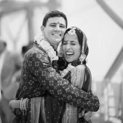 A beautiful, spontaneous hug between a cross-cultural couple right after their ceremony. This black and white photograph freezes a moment of pure happiness and relief, highlighting the universal language of love.