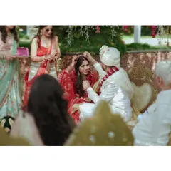 A touching moment during the wedding ceremony. The groom is applying sindoor, and the bride's serene expression is just beautiful.