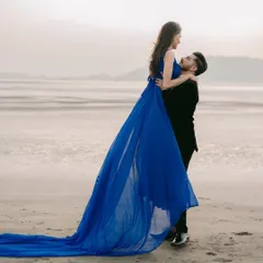 Lost in the moment, and in your arms. This flowing blue gown adds a touch of romance and movement to this beautiful beach pre-wedding photograph.