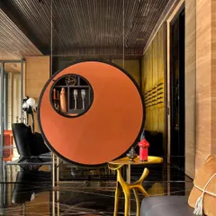 In this lounge, a bespoke circular bar storage unit hangs like a piece of art. The design echoes the circular motifs found throughout the home, creating thematic harmony and adding a unique, functional sculpture to the room.