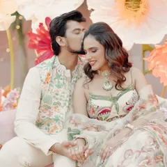 A sweet moment between Janvi and her partner during her Mehndi celebration. Her makeup is soft and radiant, with a focus on fresh skin to complement the floral, garden-party theme of her event.