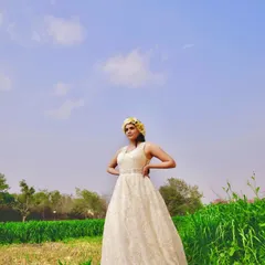 For this photoshoot in a field, I designed a bohemian-inspired A-line gown using a beautiful textured lace. The simple halter neckline and flowing skirt create an effortless, romantic vibe, which I styled with a yellow floral crown for a touch of color.