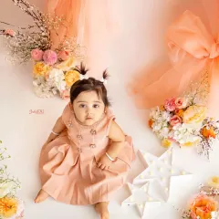 This little darling looks so sweet in her peach dress, surrounded by matching flowers. This theme is perfect for a soft and elegant milestone session.