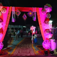 Here is the same Mehendi gate from a different angle at night. The pink uplighting enhances the colors of the fabric and makes the decorative umbrellas and hangings stand out.