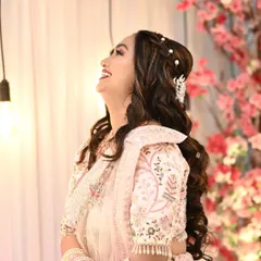 A happy and radiant bride-to-be at her engagement. The soft pink makeup and romantic, wavy hairstyle with pearl accessories create a dreamy and beautiful look.