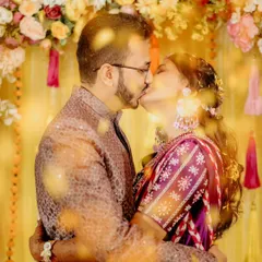 A close-up of the couple's kiss, with flower petals creating a beautiful, dreamy foreground. It's a romantic and artistic take on the haldi ceremony.
