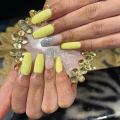 A bright and sunny yellow set with a silver glitter accent nail on long, square-shaped extensions.