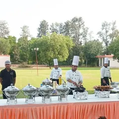 Our team of chefs at an outdoor live station, preparing burgers and other grilled items. We can set up a complete live kitchen in any outdoor venue to serve fresh and hot food.